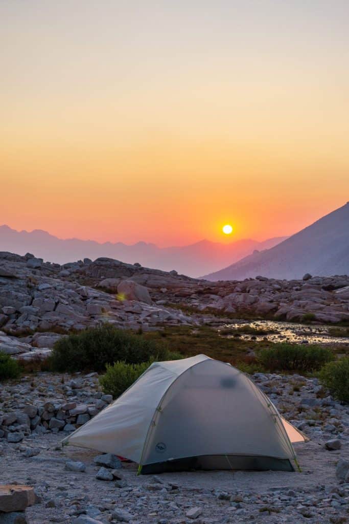 high Sierra camping scene with a tent at sunset in remote mountain terrain.