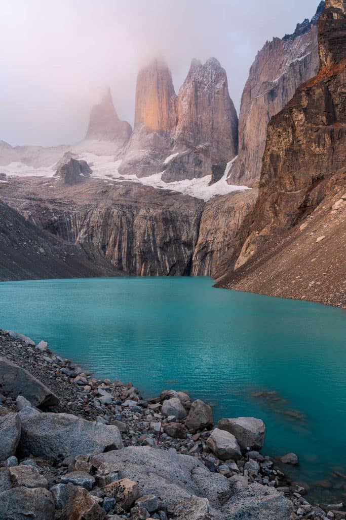Serene mountain lake with towering peaks and snow patches in the background