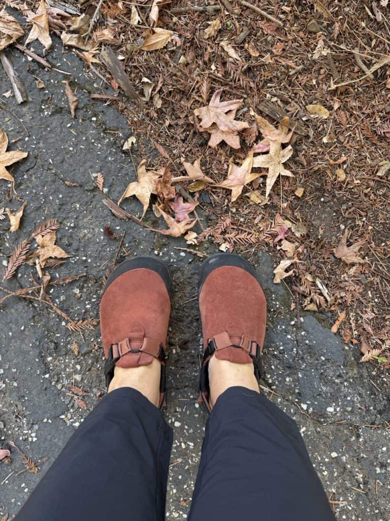 rust red clogs on feet