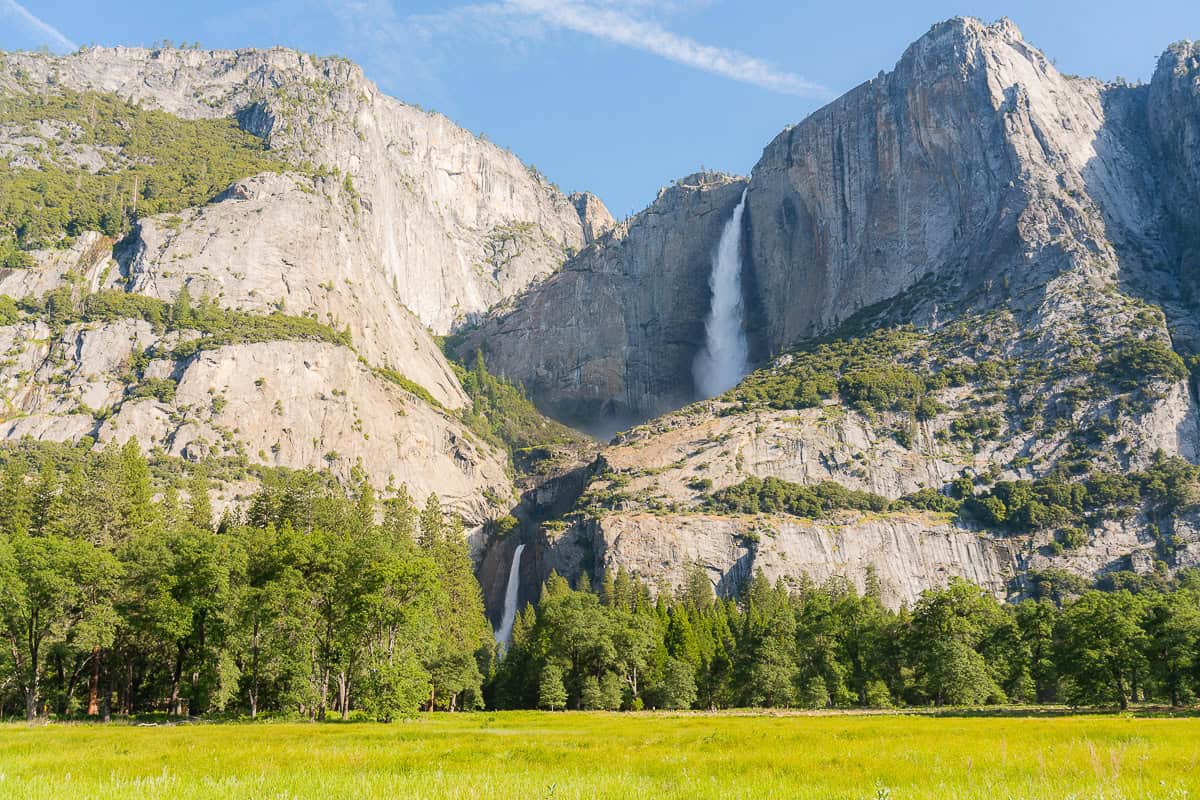 Yosemite Falls flowing from the rock face as seen from Cooks Meadow