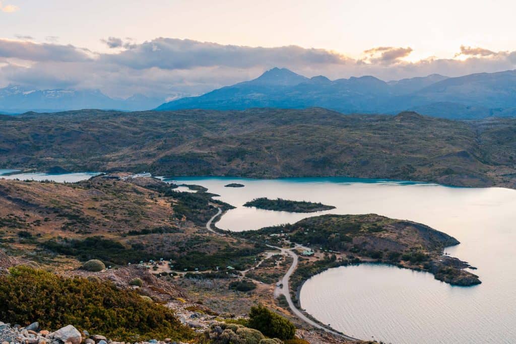 Breathtaking mountain landscape with winding road and lake, outdoor adventure, hiking, nature photography.