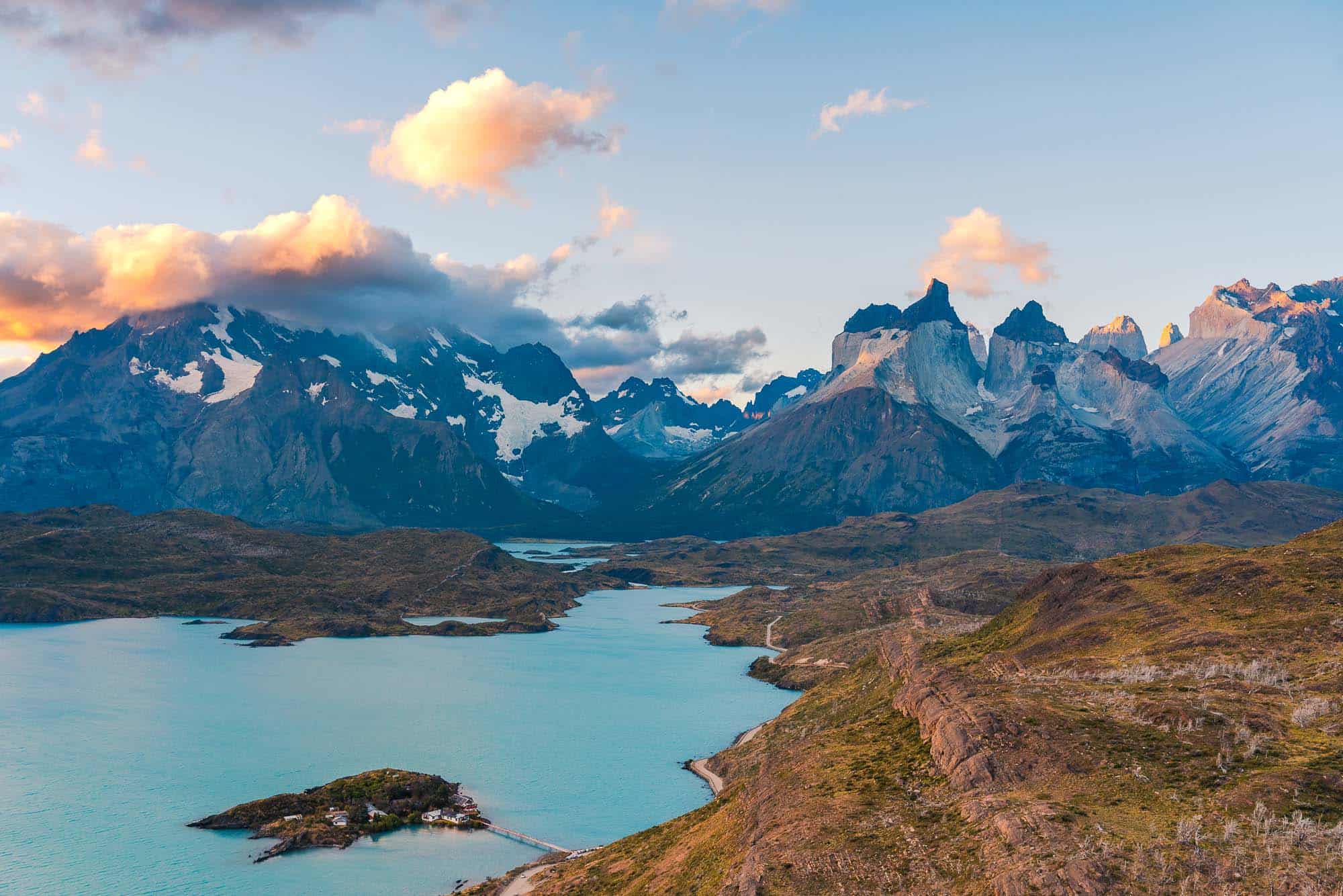Breathtaking mountain landscape with snow-capped peaks and a serene turquoise lake, you'll see when visiting torres del paine in Chile