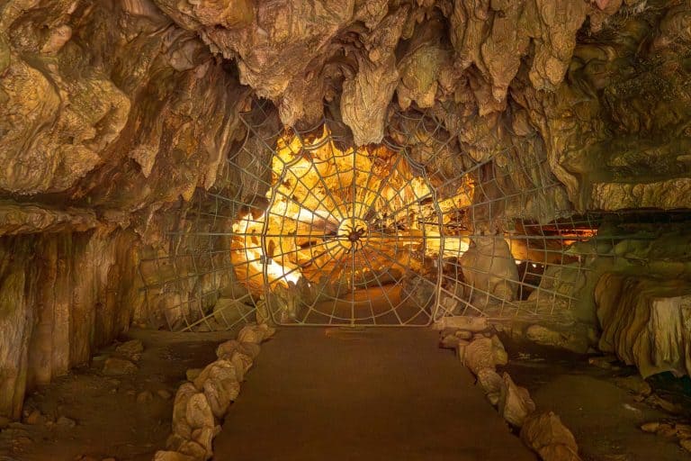 a spider-web shaped metal door blocks the entrance to the crystal cave in sequoia national park.