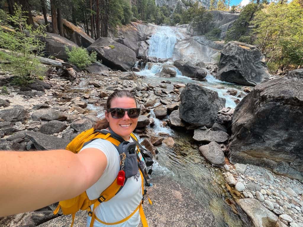 Hiker taking a selfie near a waterfall in Kings Canyon National Park.