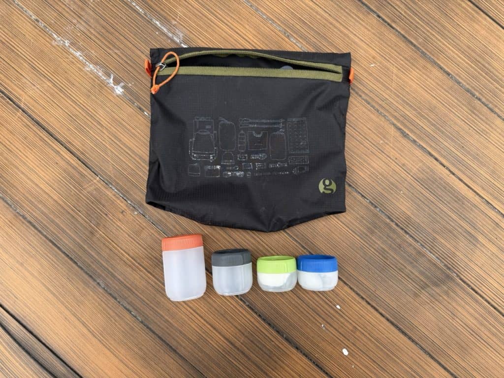 A zippered stuff sack and reusable containers for backpacking toiletries.